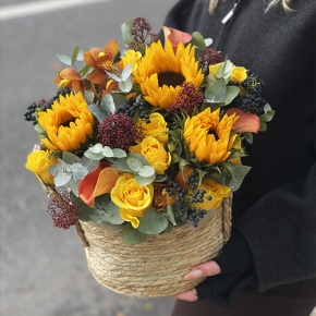 Композиция в сумке "Тональность" из подсолнухов, калл, ягод вибирнума, лимонных роз, скиммии и орхидеи в Серпухове