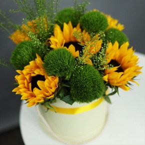 Композиция в шляпной коробке из подсолнухов и диантусов люкс в Серпухове